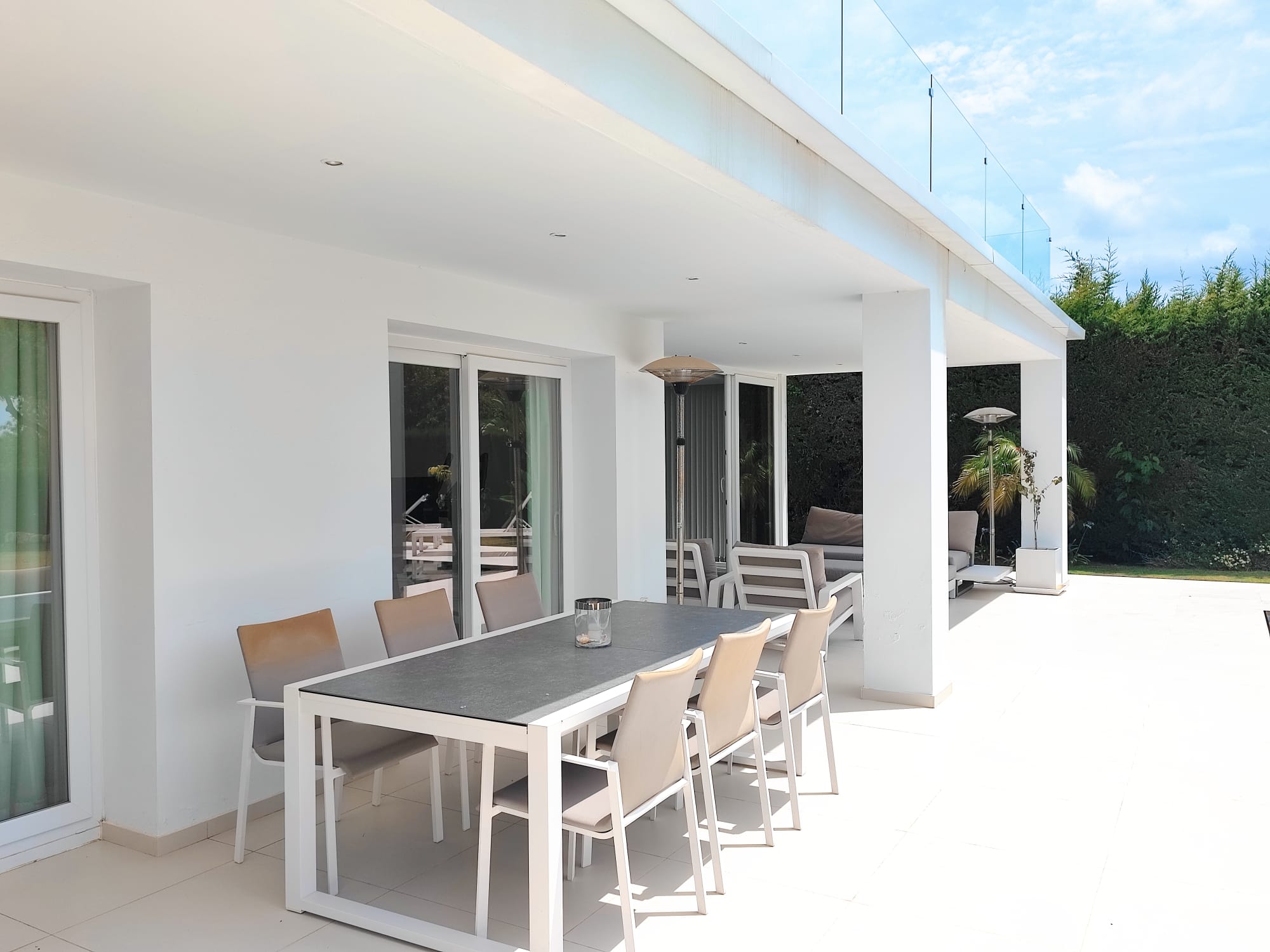 Covered outdoor dining terrace with long table for eight under the porch